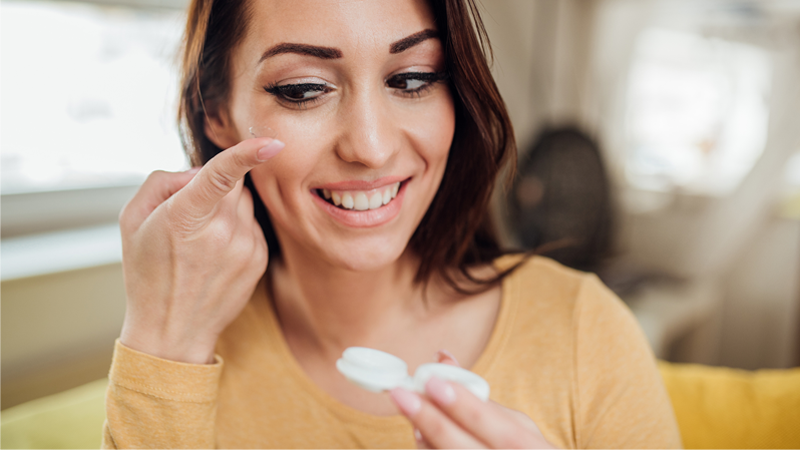 woman holding a contact lens