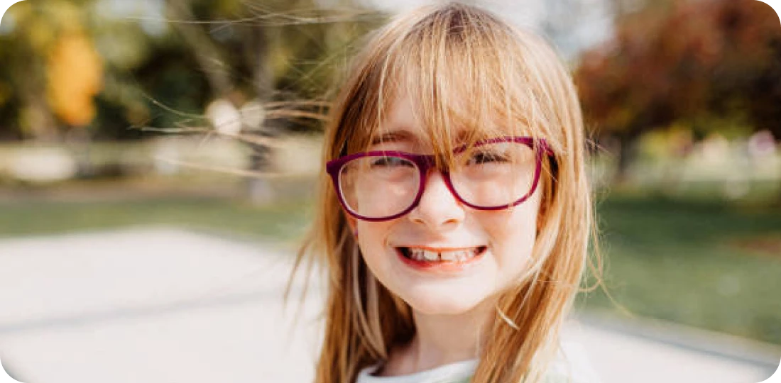 Smiling girl wearing glasses outdoors
