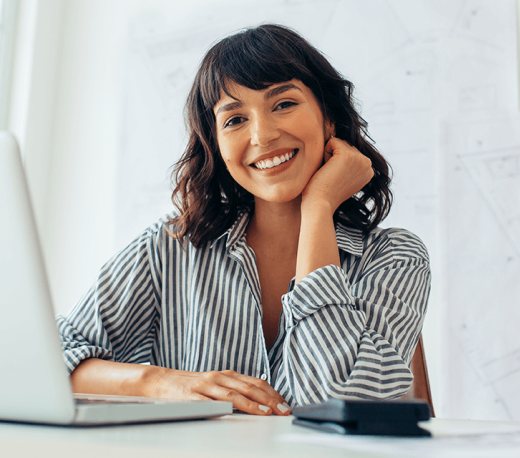 woman smiling and using a laptop